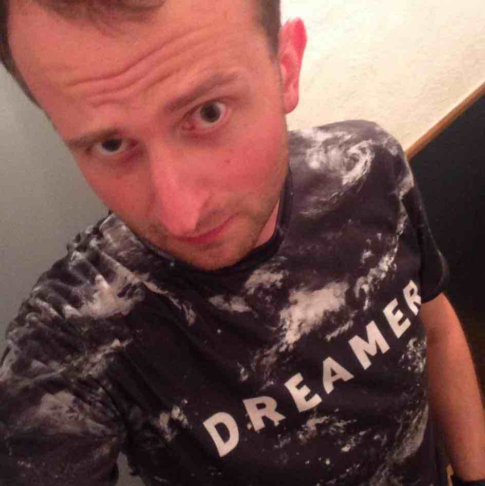 A photo of me: gazing into the camere in a Dreamer t-shirt.